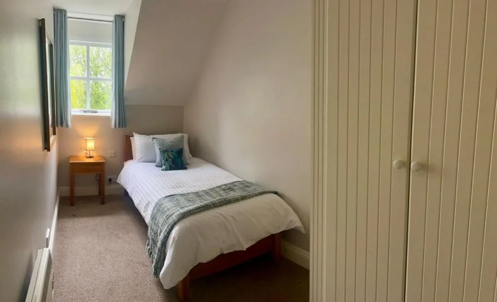 Single bedroom with made-up bed and wardrobe